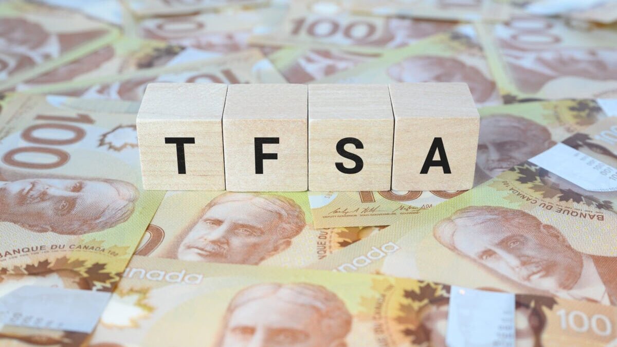 TFSA (Tax-Free Savings Account) on wooden blocks and Canadian one hundred dollar bills.